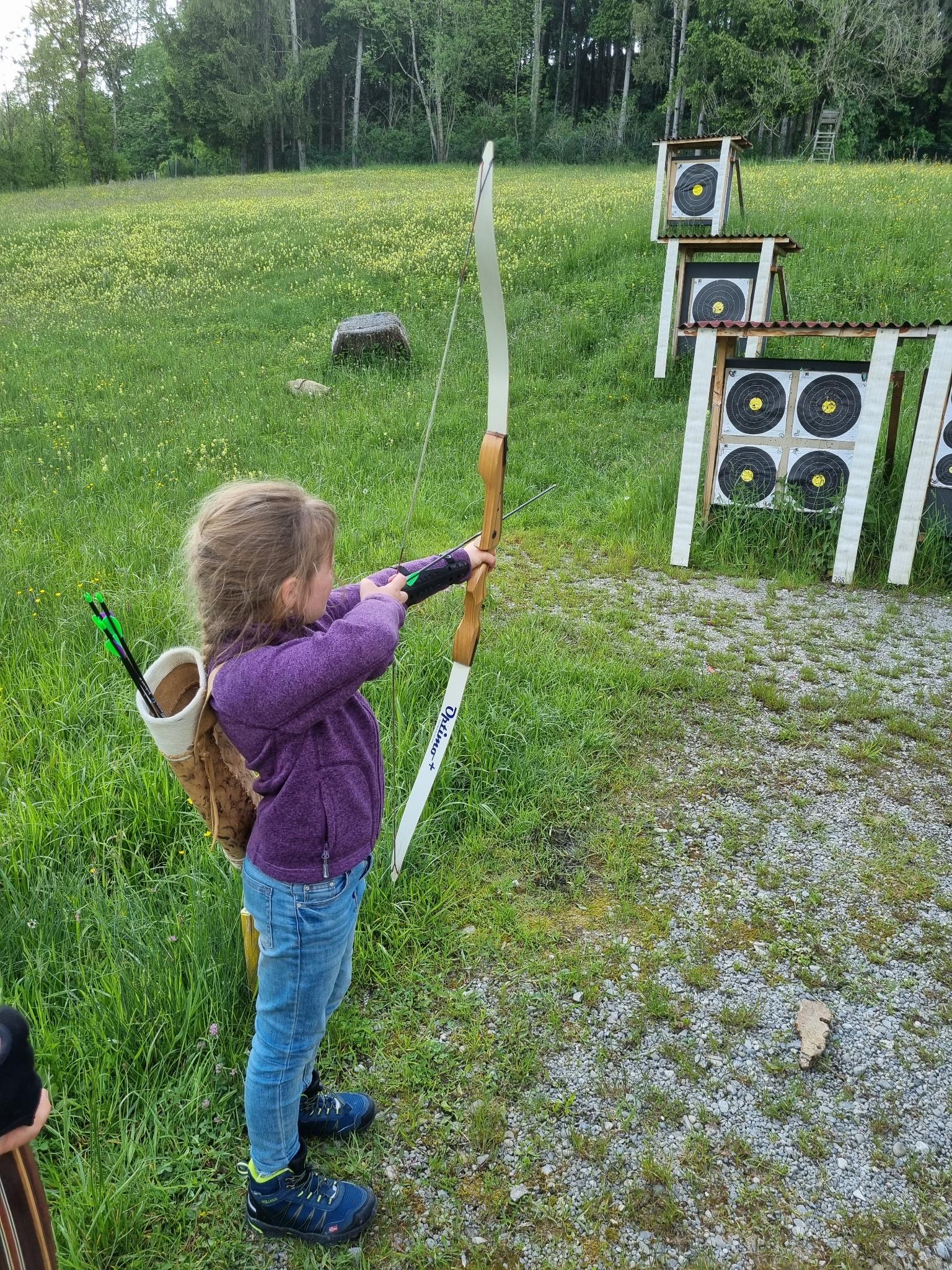 Mädchen zielt mit Recurvebogen auf FITA-Scheibe